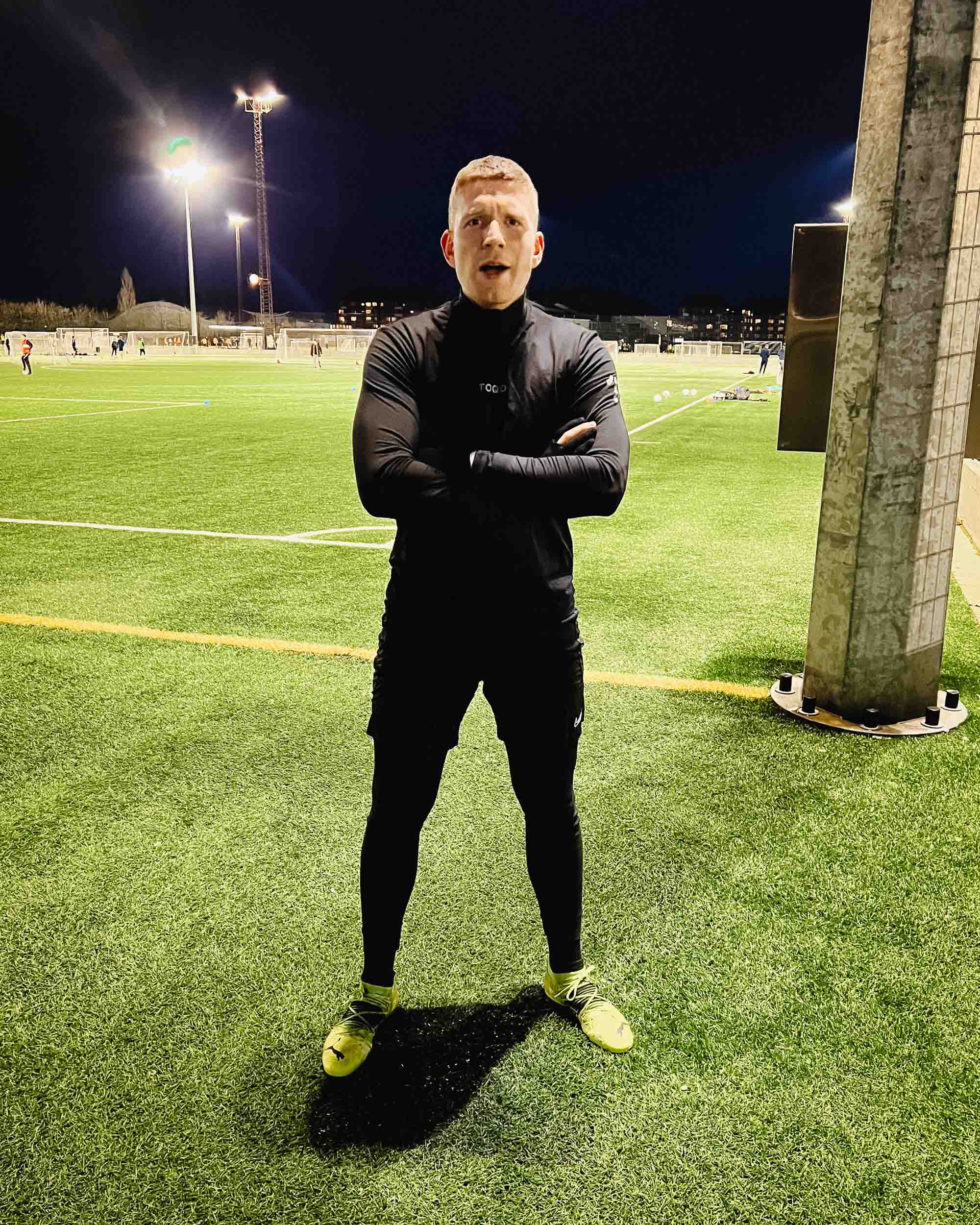A man standing on a football field in TOQO clothes