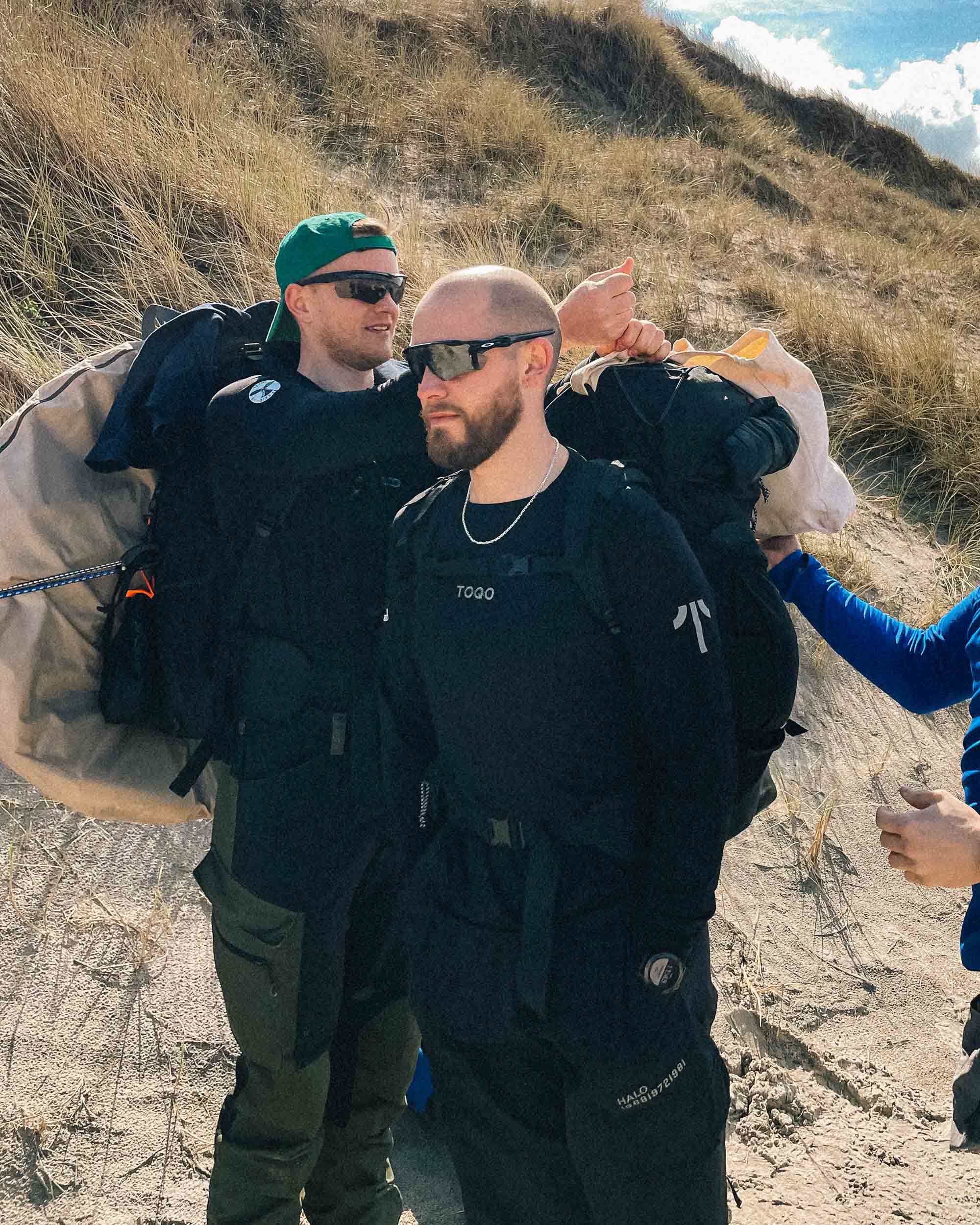 Two guys standing at a beach in TOQO shirts