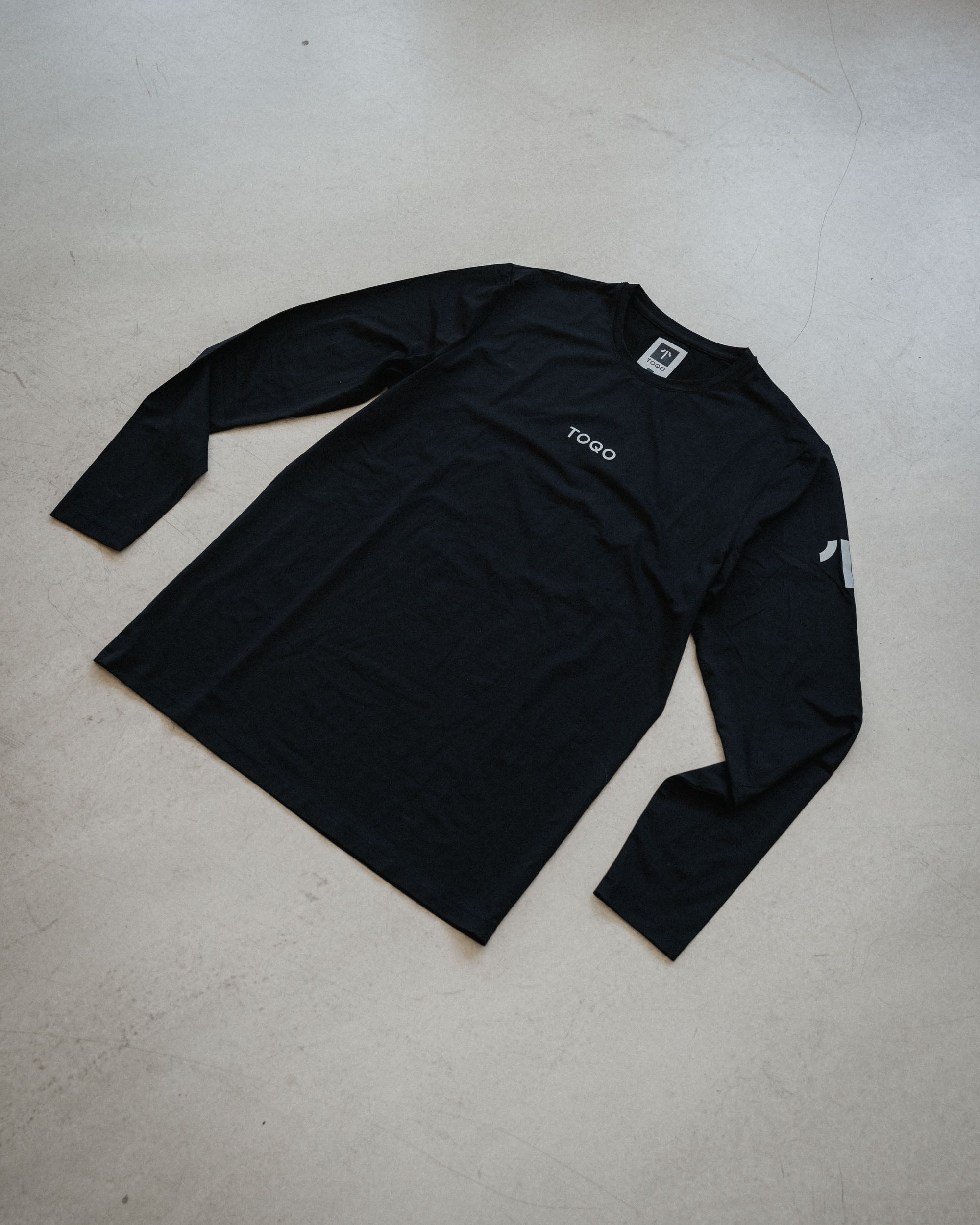 A TOQO longsleeve laying on the ground